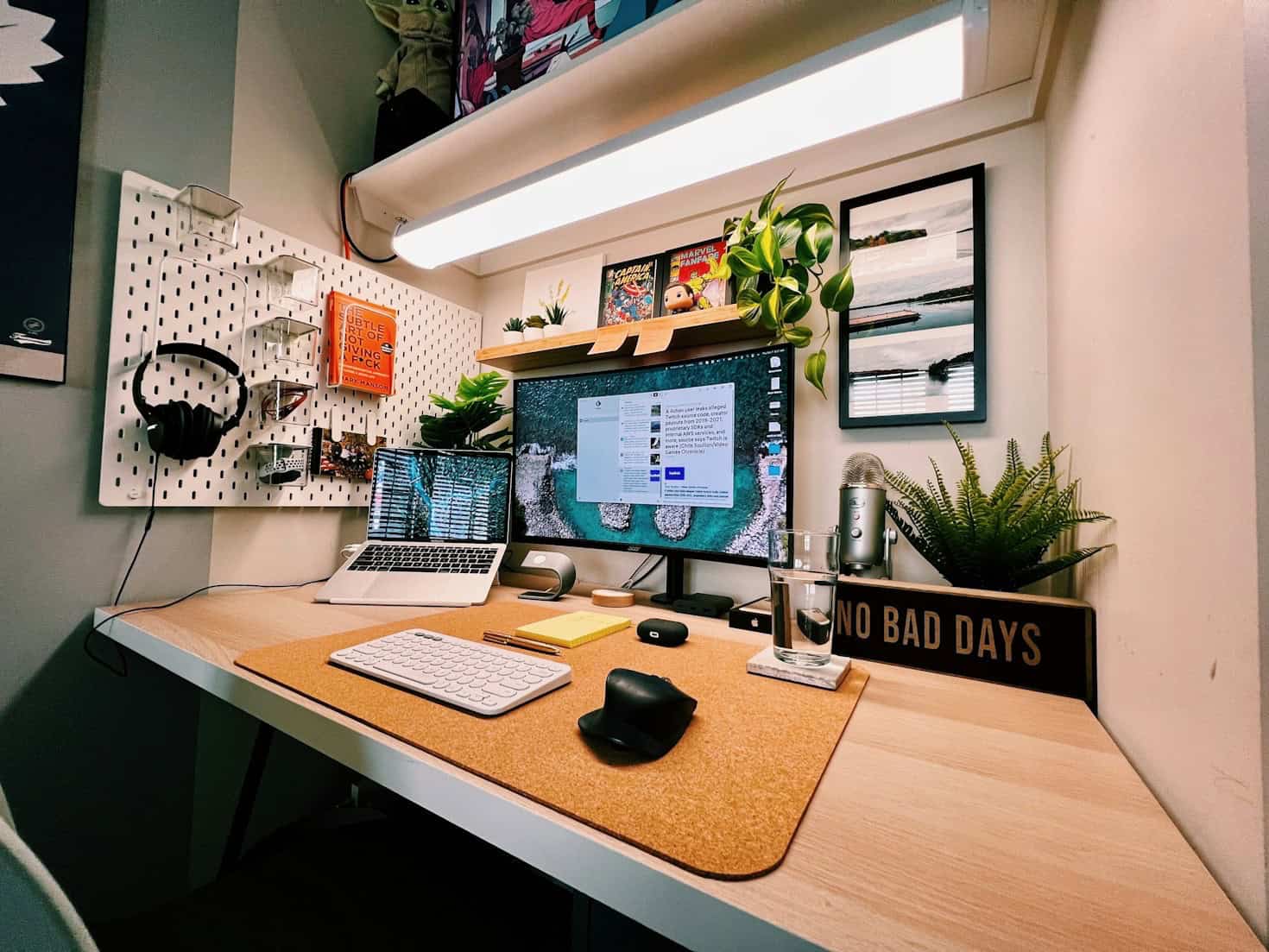 escritorio ajustable en altura con iMac, plantas y accesorios ergonómícos para productividad en trabajo remoto 2026