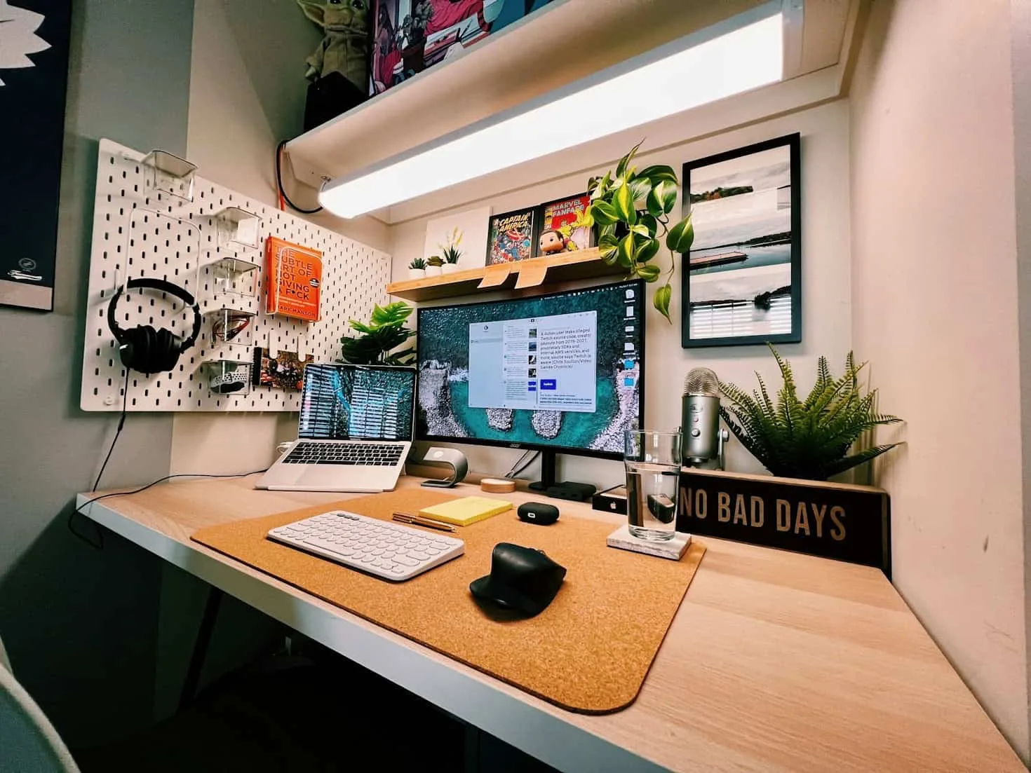 escritorio ajustable en altura con iMac, plantas y accesorios ergonómícos para productividad en trabajo remoto 2026