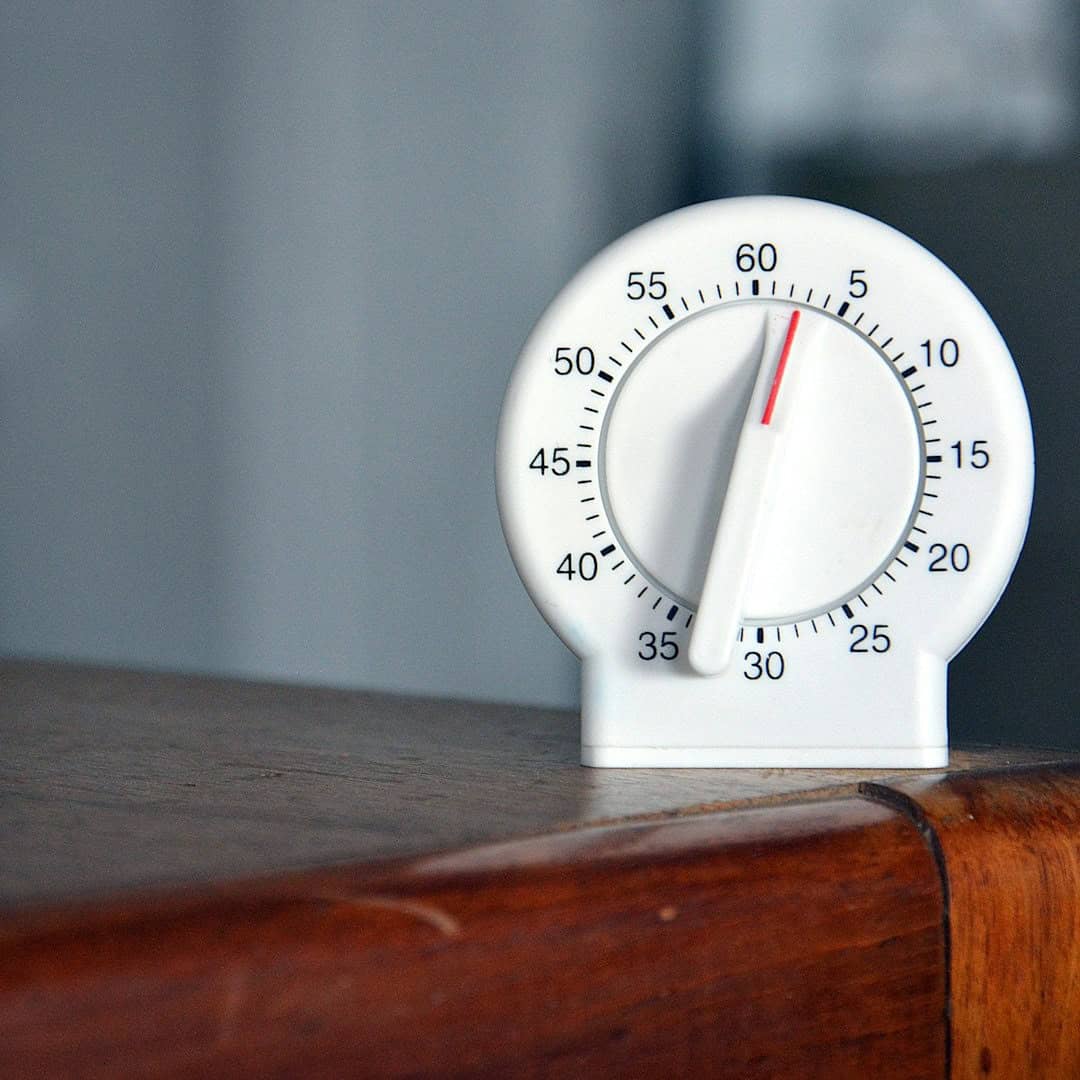 Temporizador mecánico blanco mostrando la hora con números de 0 a 60 minutos para gestión del tiempo